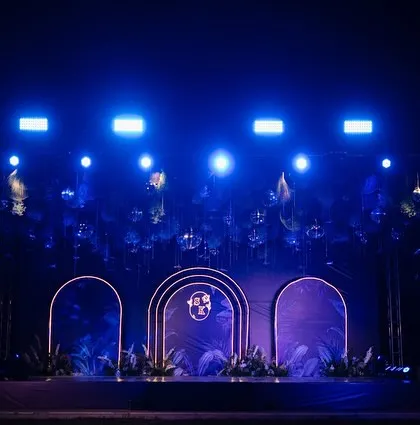 The Sangeet stage, ready for a night of performances. The clean, modern design with the couple's monogram and dramatic lighting set the scene for an unforgettable party.
