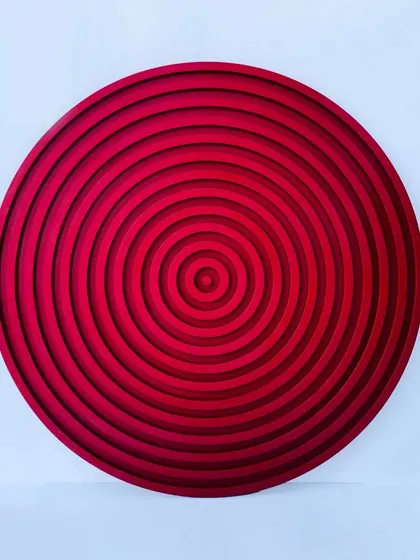 A straight-on view of the red concentric circles art. The gradient of reds, from light to dark, adds to the illusion of depth.