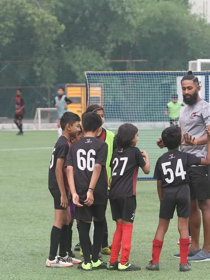 A coach addresses his team during the Summer Camp. Guidance and mentorship are key pillars of our program.