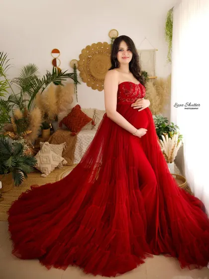 A beautiful portrait in a red tulle gown, taken in our bright and airy studio. The natural light from the window creates a soft and flattering glow.