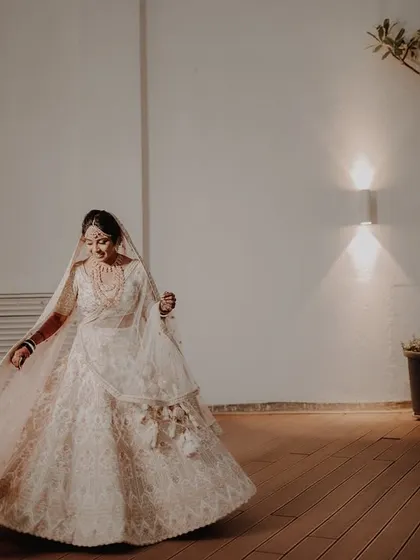 A bride twirls on a wooden deck at night, her lehenga flowing around her. This shot captures the dream of every bride to have her fairy tale moment.
