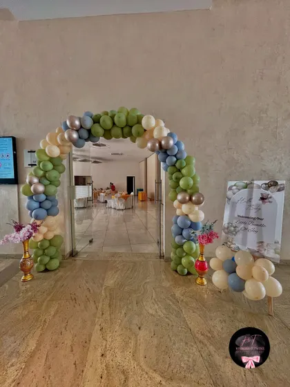 The entrance for the 'Welcome Baby Boy' party, featuring a classic balloon arch in sage, blue, and beige, setting a calm and welcoming tone for the event.