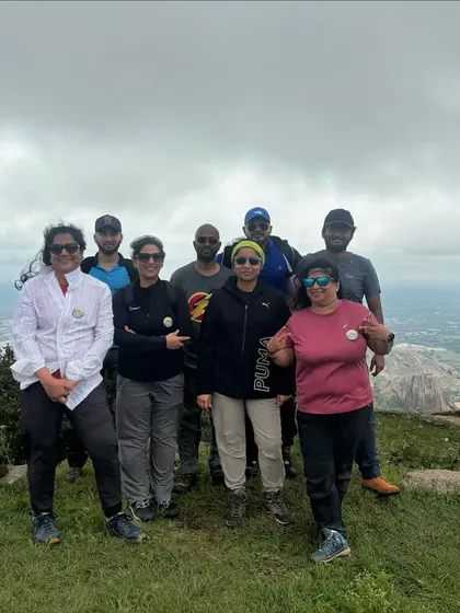 Posing for a group photo against a cloudy sky. We trek in various weather conditions, always equipped to ensure the group's safety and comfort.