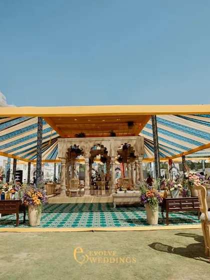 A wide shot of the outdoor venue at the Leela Palace Jaipur, showing the grand tented structure against the beautiful architecture of the hotel.