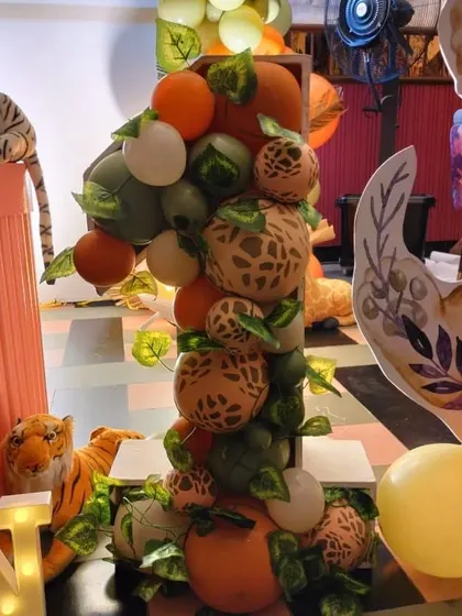 Close-up of the custom number one prop, filled with safari-print and green balloons, adding a unique touch to the decor.