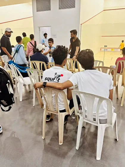 A candid moment of mentorship and team bonding between matches at the JSW Memorial Open.