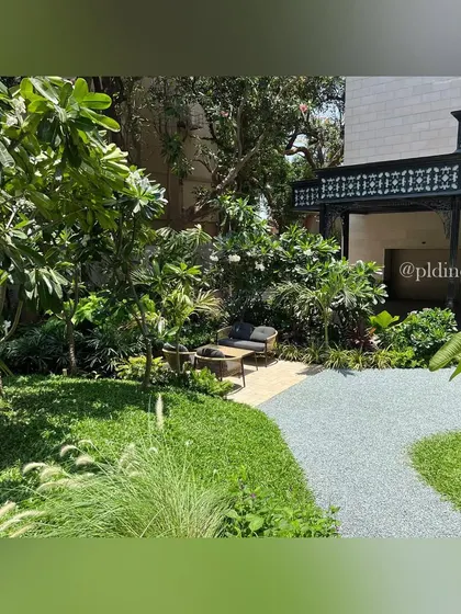 A small seating patio is tucked away in a corner of the entrance garden, surrounded by Frangipani trees and flowering shrubs. This creates a private nook for residents to enjoy the garden upon arriving or leaving home.