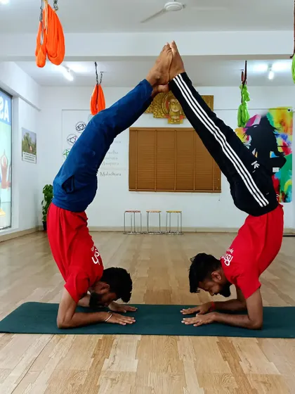 A partner inversion pose that requires immense strength, balance, and communication between both yogis.