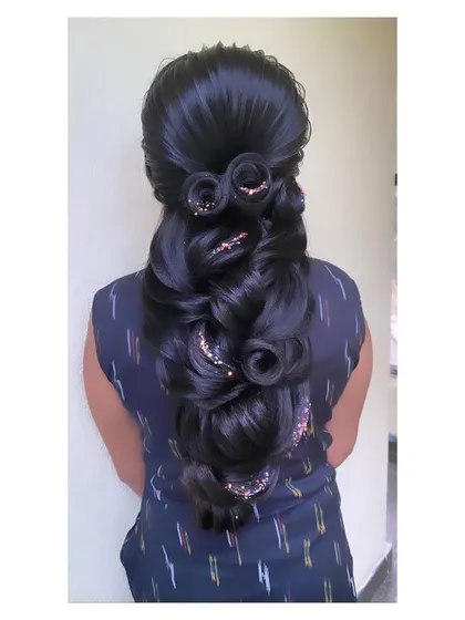 A highly creative hairstyle featuring multiple sculpted hair roses within a cascading design. This is a show-stopping look that demonstrates a high level of technical skill.