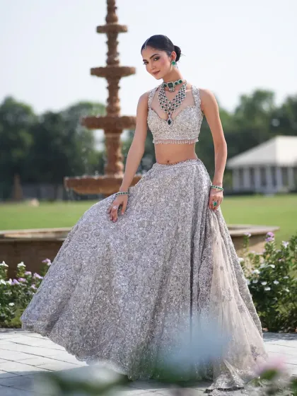 A full-length shot showcasing the flow and flare of this magnificent silver lehenga, perfect for a grand reception.