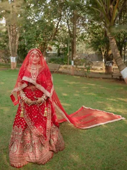 A stunning portrait of the bride with the long trail of her dupatta spread out on the grass. We love creating these dramatic, elegant shots.