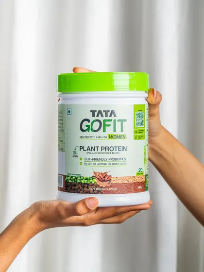 Hands holding a tub of plant protein. This simple shot is effective for social media, focusing entirely on the product.