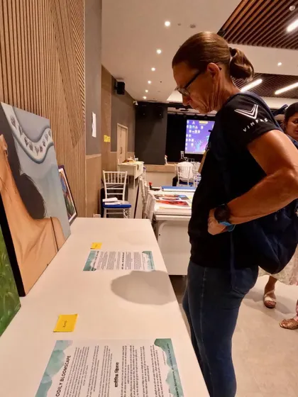 A visitor looking at my paintings at my first exhibition. It's a humbling experience to see someone connect with your work.