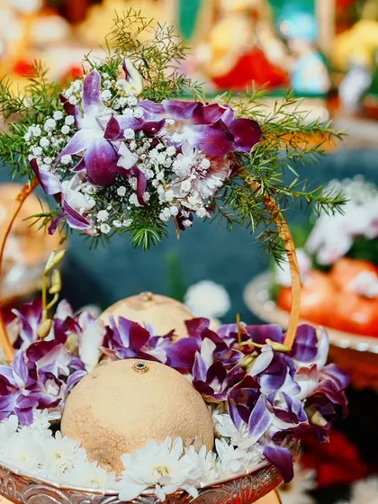 A beautiful thamboolam tray featuring coconuts decorated with purple orchids. This type of arrangement is essential for many South Indian ceremonies, and I ensure each one is crafted to be both traditional and beautiful.