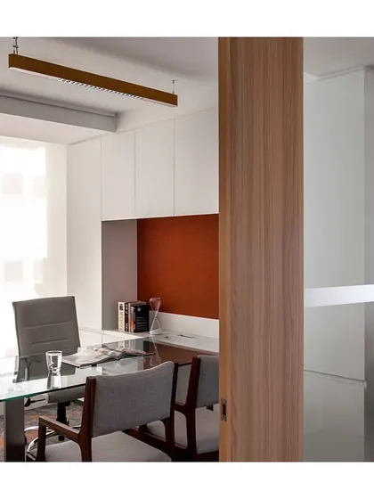 A view into a cabin in 'The Office with A View'. The design uses a glass wall to maintain a sense of openness while providing acoustic privacy. The interior features a clean, functional layout with ample storage.