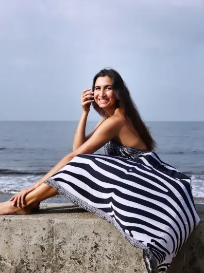 A happy and relaxed seated portrait on the sea wall. The model's bright smile and easy posture make this a very engaging and positive image.
