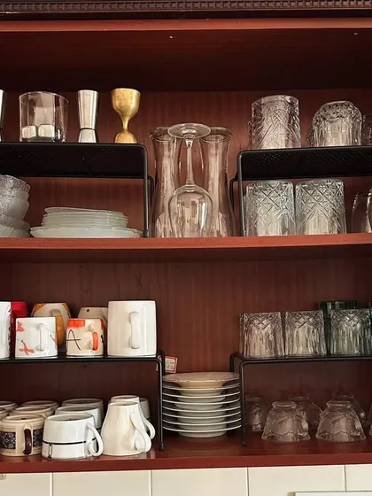 Using shelf risers in a crockery cabinet is a game-changer. It allows you to store different types of plates, bowls, and glasses without risky stacking.