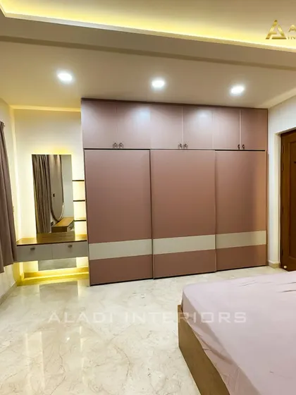 A full view of a bedroom featuring a large wardrobe with a dusty rose and white finish, perfectly complementing the room's color scheme.