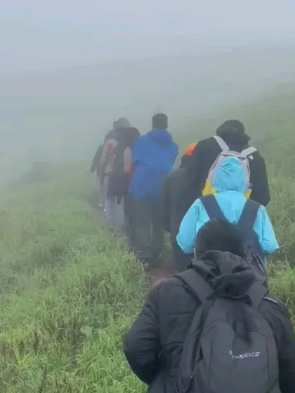 A line of trekkers disappearing into the thick fog on the Bandaje trail.