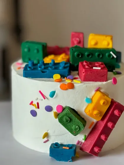 A slightly different angle of the edible LEGO dream. The colorful chocolate blocks and sprinkles make this a fun and interactive cake for any LEGO enthusiast.