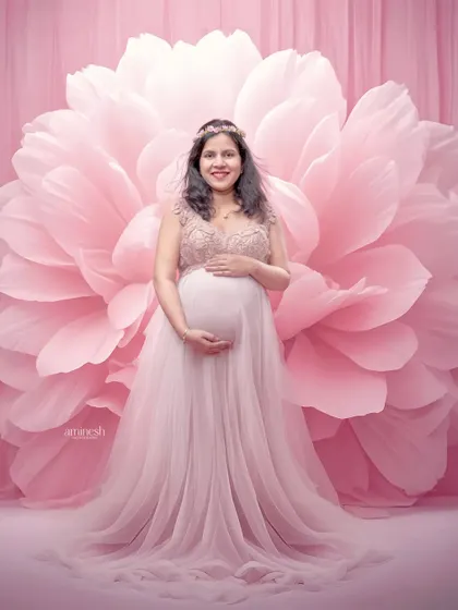 This portrait combines a delicate pink gown with an oversized flower backdrop. The soft, tonal pinks create a very gentle and feminine image, perfect for celebrating your pregnancy.