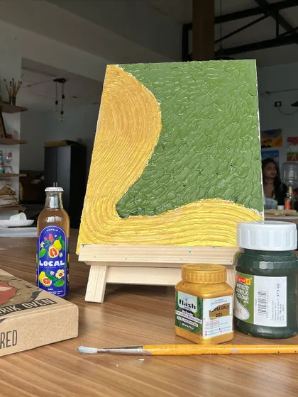 The setup for our textured art workshop, complete with a finished example, paints, and of course, snacks and drinks to fuel the creativity.