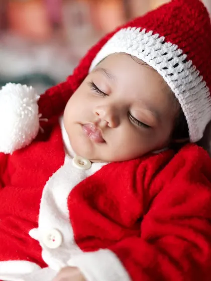 A tiny Santa sleeping peacefully. Our Christmas shoots are perfect for newborns too, creating the most adorable holiday cards.