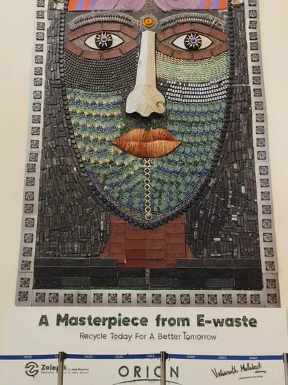 A poster displayed at Orion Mall, presenting the mural as "A Masterpiece from E-waste." This simple but powerful statement, placed next to the artwork, reinforces the message of recycling for a better tomorrow.