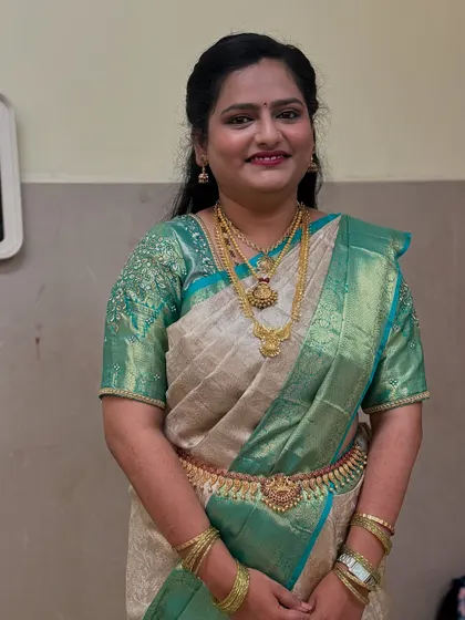 A beautiful smile from Rakshitha at her reception. You can see how the saree pleats are neatly tucked and secured, giving her a polished and graceful appearance throughout the event.