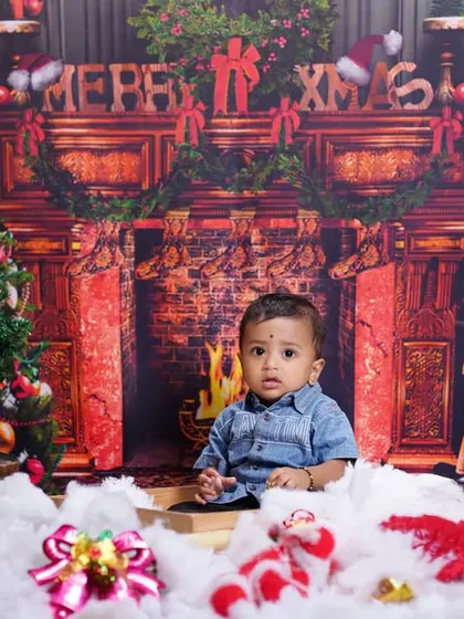 A classic Christmas fireplace scene created in the studio. This festive backdrop with a Christmas tree and decorations is perfect for holiday family photos.