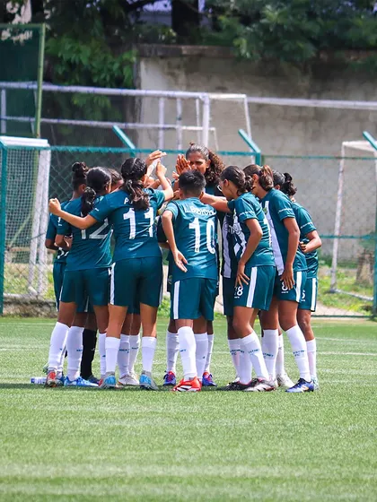 The pre-game huddle. Our girls' team comes together for a moment of unity and focus before the start of an important match.