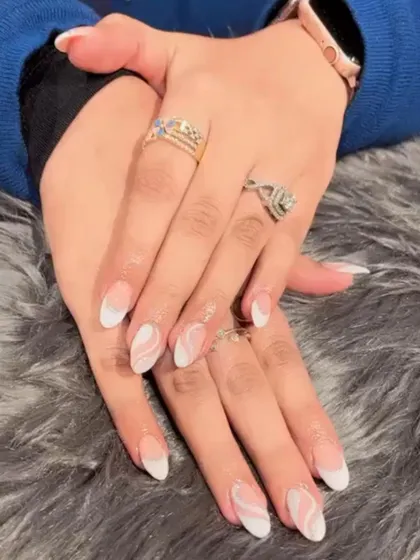 A beautiful white marble swirl design over a natural base, combined with classic white French tips for an elegant, mixed-media look.