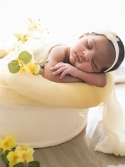 A side profile of the same yellow-themed setup, highlighting the baby's sweet, chubby cheeks and tiny features.