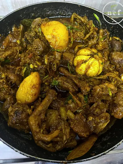 My spicy duck curry, cooked with whole potatoes and garlic, simmering in a pan.