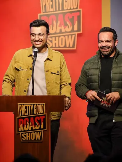 Two hosts sharing a laugh on stage. Capturing the chemistry between performers is key to documenting a successful show.