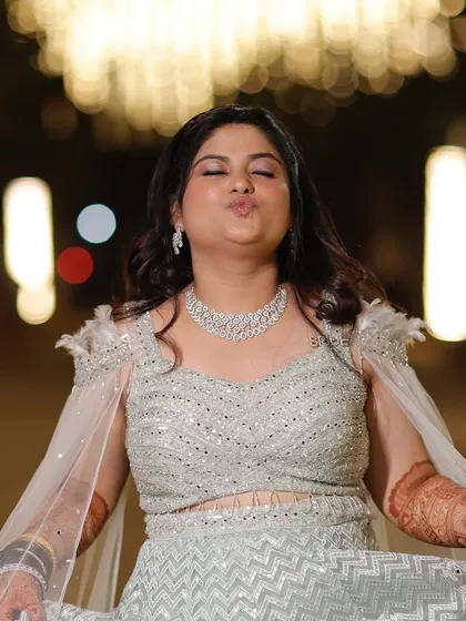 A playful moment from the Sangeet night. The makeup is fun and glamorous, with a pop of pink on the lips and shimmery eyes.
