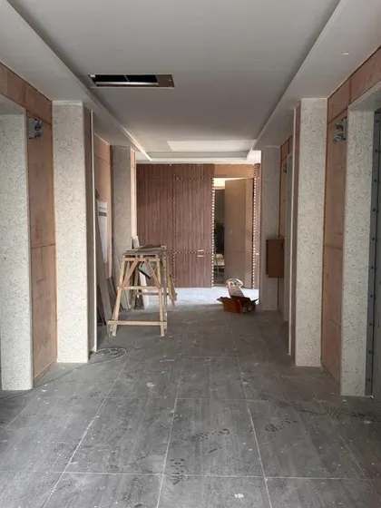 Nearing completion at the Carlsberg head office in Gurugram. This image shows the elevator corridor with finished flooring and wall panels, awaiting the final branding and lighting elements that will complete the space.