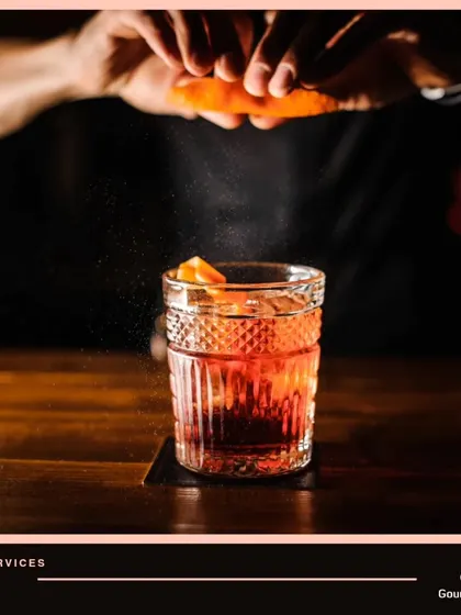 Sit back and relax while we handle the party, from the food to the bar. This image captures a bartender adding the final orange peel garnish to a classic cocktail.