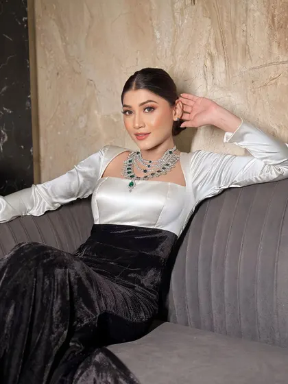 Recreating Kiara Advani's glamorous reception look. The black and white gown is paired with a sleek bun and emerald jewellery for a touch of color.