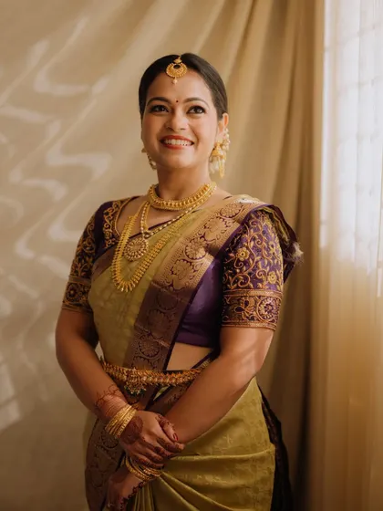 A classic bridal portrait. The soft, elegant makeup provides a flawless finish that enhances her features without overpowering the beauty of her traditional attire and gold jewellery.