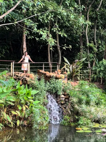 A guest stands by a small waterfall and pond, a tranquil spot to connect with nature.