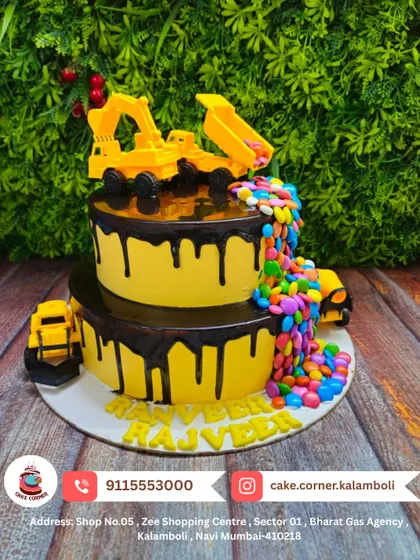 A fun two-tier construction site cake with chocolate drip and a candy waterfall. The toy trucks and diggers make it an exciting choice for kids who love big machines.