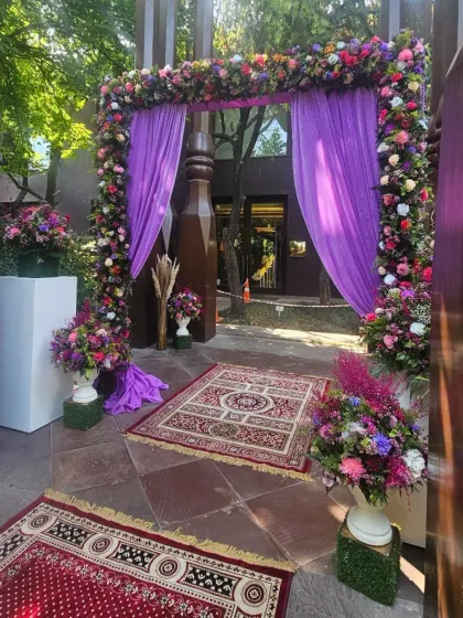 A closer view of the vibrant purple floral archway. The combination of deep purples, pinks, and greens creates a lush and inviting entrance, perfect for making a grand statement.