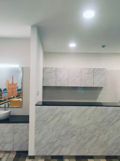 A clean and functional servery area within the TVS canteen. The use of marble-finish laminates and simple cabinetry ensures the space is durable, easy to maintain, and visually unobtrusive.