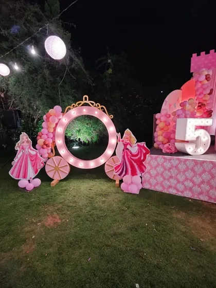 A princess carriage photobooth with marquee lights, perfect for a fairytale-themed party.