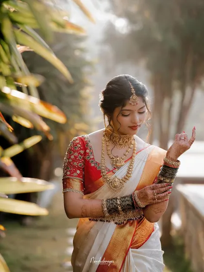 A candid portrait of the bride adjusting her bangles. The soft, natural light and her gentle movement create a beautiful and serene image.