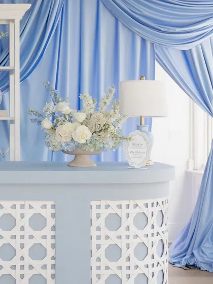 Details matter. This corner of the bar features a custom-latticed front, a beautiful floral arrangement, and a classic table lamp, all in coordinating shades of blue and white to perfect the theme of this chic baby shower.