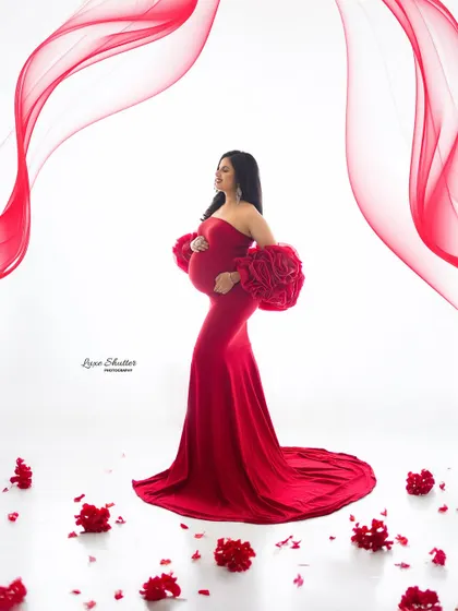 Elevating motherhood with style. This shot uses creative effects with red light streaks to complement the stunning red gown.