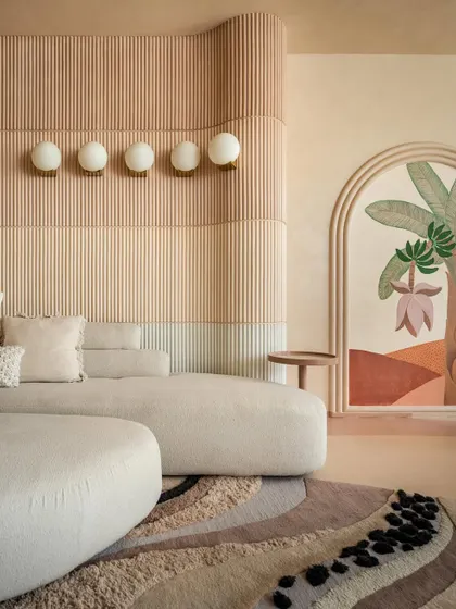 A close-up of the layered wall paneling in the "House of Mousse." The gradient of earthy tones and fluted texture adds depth and warmth, complemented by the soft glow of the wall-mounted lights.