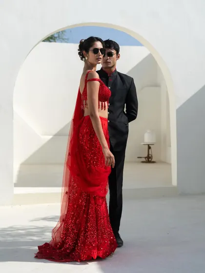 Red hot and ready for any party. This couple look features our famous red sequin saree paired with a classic black bandhgala for a bold statement.